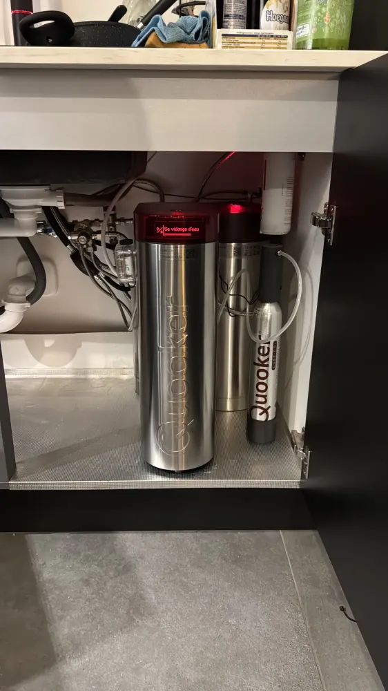Système Quooker avec bouteille de CO2 et unité de traitement sous un évier.